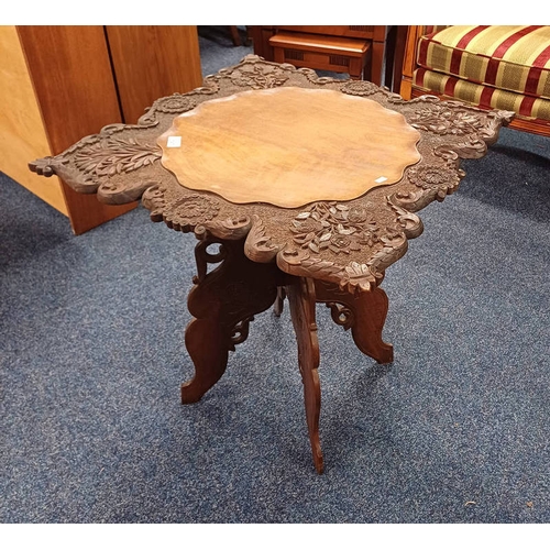 197 - INDIAN HARDWOOD SQUARE OCCASIONAL TABLE WITH DECORATIVE CARVED BORDER ON SHAPED FOLDING SUPPORTS, 64... 