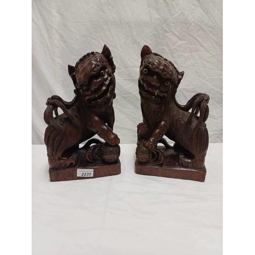 2237 - PAIR OF CARVED WOODEN ORIENTAL MYTHICAL FIGURES, 31 CM TALL