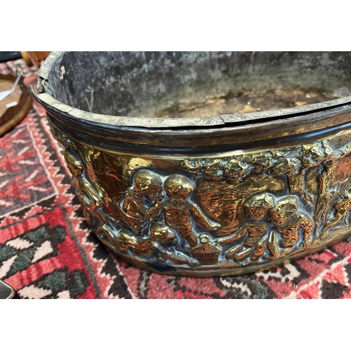 2006 - LATE 19TH OR EARLY 20TH CENTURY BRASS OVAL BIN EMBOSSED WITH CHERUBS IN FOREST SCENE, 49CM ACROSS