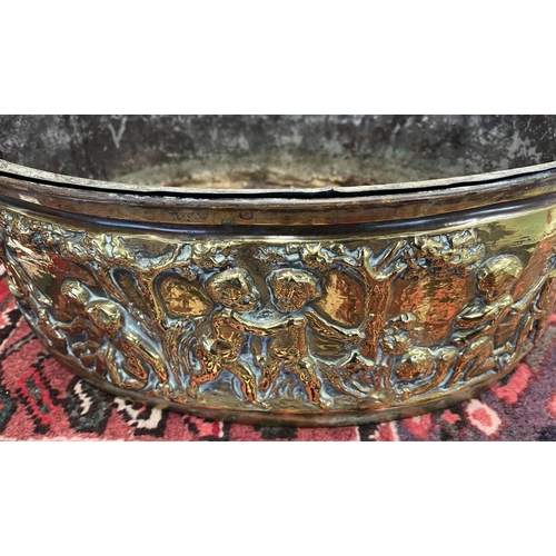 2006 - LATE 19TH OR EARLY 20TH CENTURY BRASS OVAL BIN EMBOSSED WITH CHERUBS IN FOREST SCENE, 49CM ACROSS