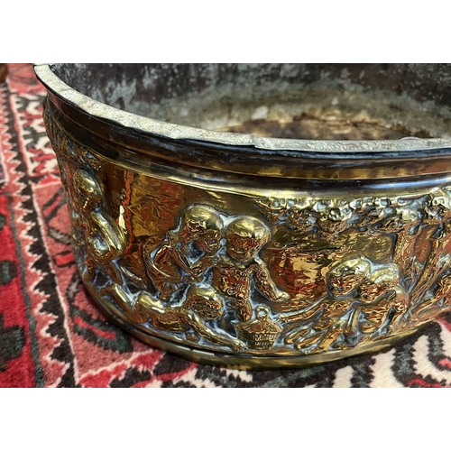 2006 - LATE 19TH OR EARLY 20TH CENTURY BRASS OVAL BIN EMBOSSED WITH CHERUBS IN FOREST SCENE, 49CM ACROSS