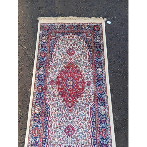 2063 - LARGE IVORY GROUND CASHMERE RUNNER WITH FULL PILE AND A TRADITIONAL MEDALLION DESIGN 502CM X 77CM
