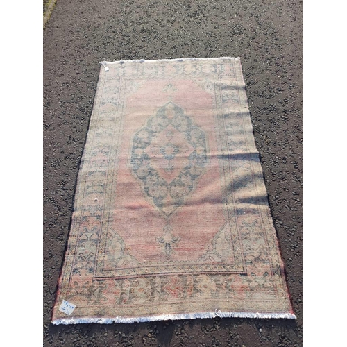 2106 - WASHED RED GROUND AND WOVEN PERSIAN VILLAGE RUG WITH CENTRAL MEDALLION DESIGN 205CM X 125CM