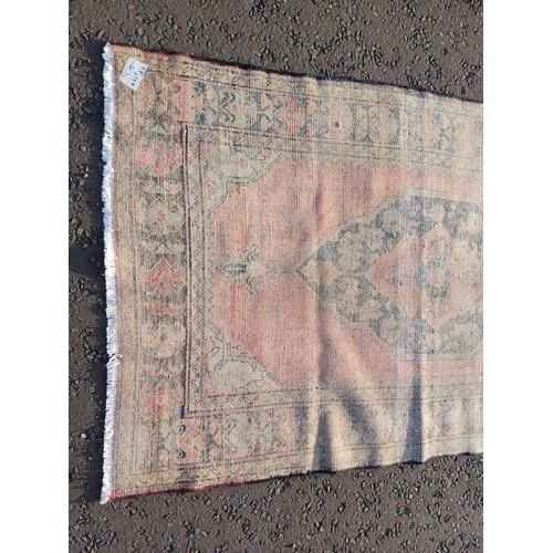 2106 - WASHED RED GROUND AND WOVEN PERSIAN VILLAGE RUG WITH CENTRAL MEDALLION DESIGN 205CM X 125CM