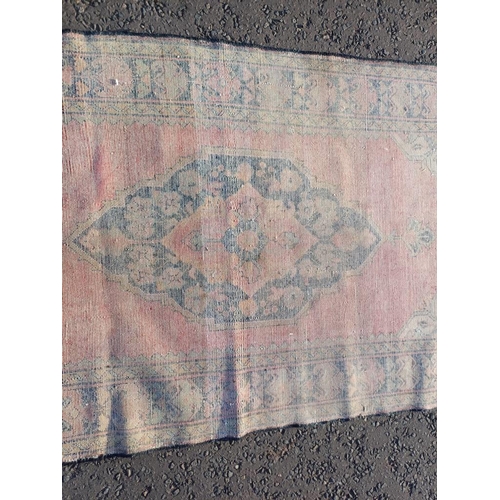 2106 - WASHED RED GROUND AND WOVEN PERSIAN VILLAGE RUG WITH CENTRAL MEDALLION DESIGN 205CM X 125CM