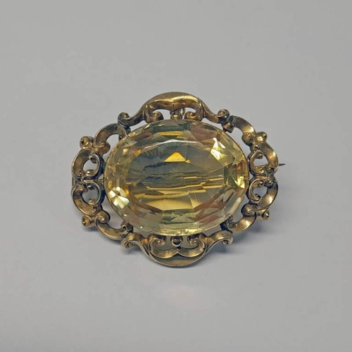 579 - VICTORIAN GOLD CITRINE SET BROOCH IN SCROLL SETTING - 5CM WIDE, 26.3G