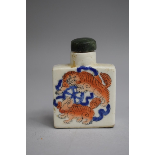 215 - A Chinese Snuff Bottle of Flattened Square Form decorated with Orange and Blue Enamels depicting Foo... 