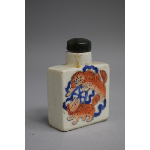 215 - A Chinese Snuff Bottle of Flattened Square Form decorated with Orange and Blue Enamels depicting Foo... 