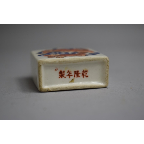 215 - A Chinese Snuff Bottle of Flattened Square Form decorated with Orange and Blue Enamels depicting Foo... 