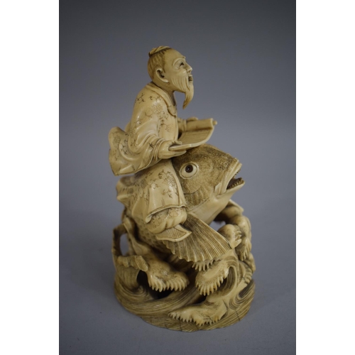 279 - A Signed 19th Century Chinese Ivory Okimono of Elder with Scroll Riding Carp. 15cms High