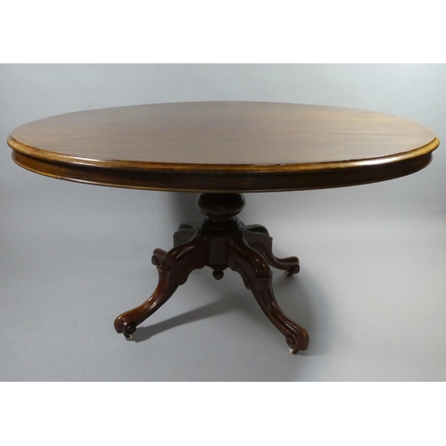 438 - A Late Victorian Mahogany Oval Snap Top Breakfast Table on Four Scrolled Supports. 134x103cms