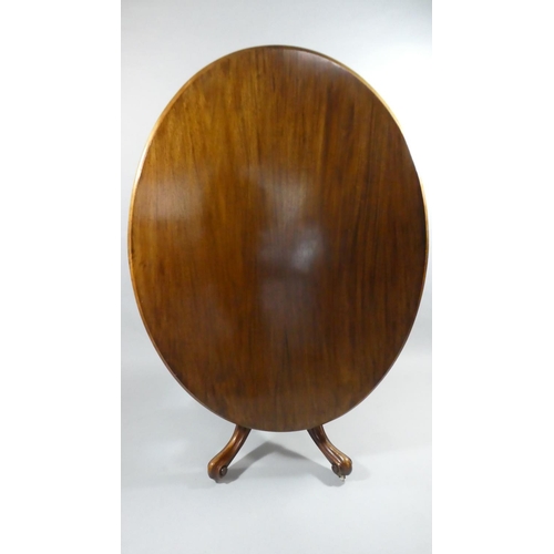 438 - A Late Victorian Mahogany Oval Snap Top Breakfast Table on Four Scrolled Supports. 134x103cms