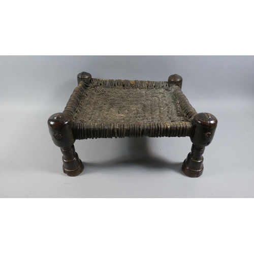 70 - A 19th Century Indian Carved Wooden Stool with a Woven Leather Seat. 42x40x20cms