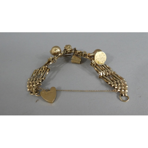 292 - A 9ct Gold Gate Link Bracelet with Padlock Clasp and Six Charms. 19.7gms