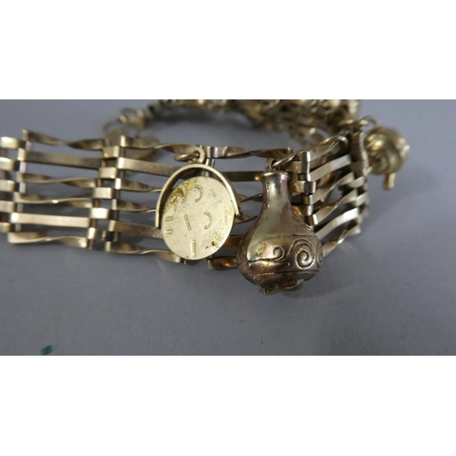 292 - A 9ct Gold Gate Link Bracelet with Padlock Clasp and Six Charms. 19.7gms