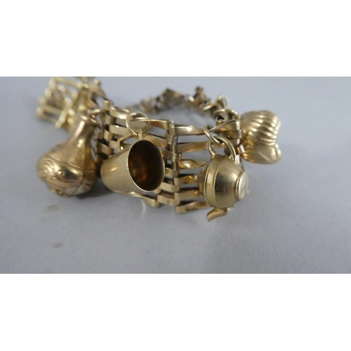 292 - A 9ct Gold Gate Link Bracelet with Padlock Clasp and Six Charms. 19.7gms