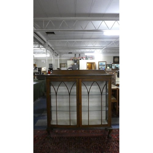 366 - An Edwardian Oak Bow Fronted Display Cabinet on Claw and Ball Feet.