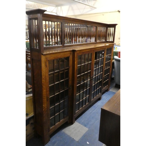 406 - A Good Arts and Crafts Oak Break Fronted Glazed Bookcase with Extended Raised Gallery, 215 cms Wide