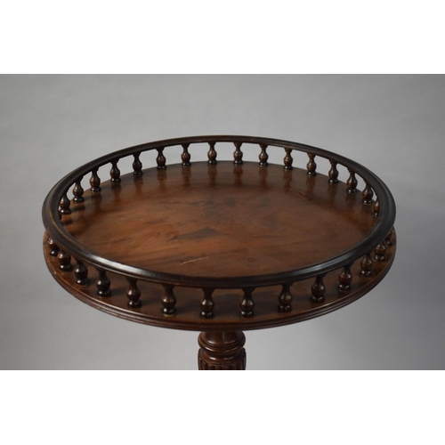 64 - A Reproduction Circular Mahogany Tripod Table with Spindle Gallery and CLaw and Ball Feet. 46cms Dia... 