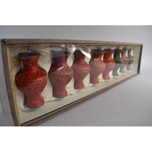 43 - A Rectangular Display Case Containing Eight Oriental Vases Exhibiting the Cinnabar Lacquering Proces... 