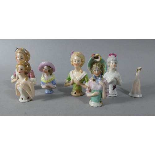 10 - A Vintage Tin Containing Seven Porcelain Pin Cushion Dolls