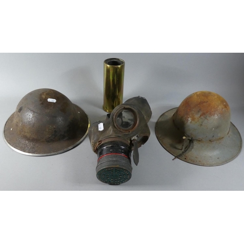 126 - Two WWII Helmets, Gas Mask and a Shell Case