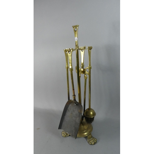 33 - A Brass Fire Companion Set on Three Claw Feet, 55cm high