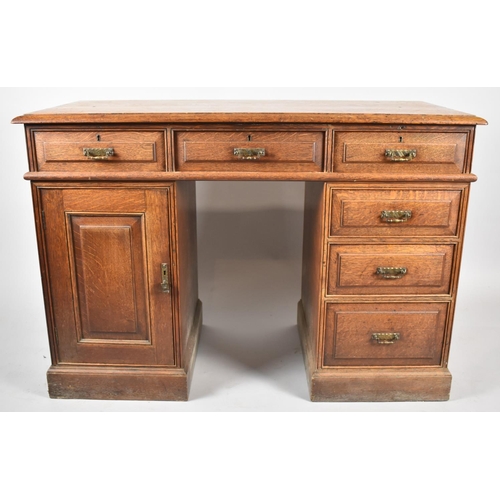 68 - An Edwardian Oak Kneehole Writing Desk with Three Top Drawers, Kneehole flanked by Three Graduated S... 