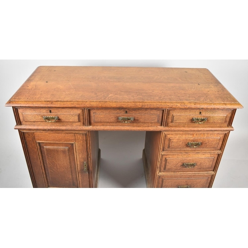 68 - An Edwardian Oak Kneehole Writing Desk with Three Top Drawers, Kneehole flanked by Three Graduated S... 