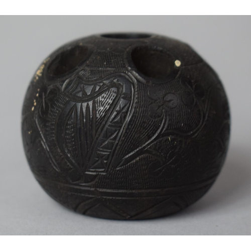 6 - A Carved Irish Bog Oak Globular Match Holder Decorated with Harp, Shamrock and Shield, 4.25cm high