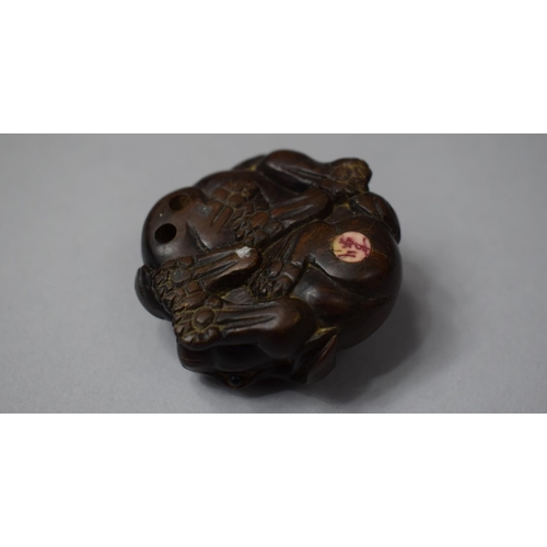 155 - A Carved Wooden Netsuke if the Form of Entwined Hares, With Inset Signed Disc to Base