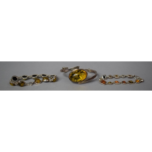 342 - A Collection of Three White Metal Mounted Amber Bracelets including one Hinged Cuff, Largest Stone 3... 