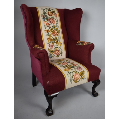 500 - An Upholstered Wing Armchair with Georgian Shaped High Back and Supported on Front Claw Feet