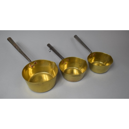 128 - A Set of Three Graduated Brass Saucepans