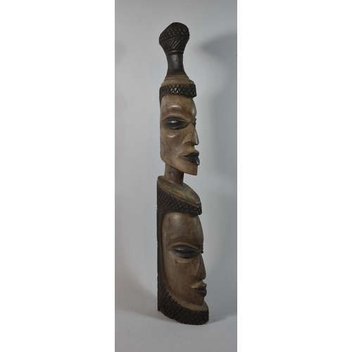 65 - A Heavy Carved Wooden Tribal Club in the Form of Two Graduated Masks, 65cm high