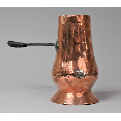 36 - An Early Iron handled Copper Side Pouring Jug, 18cm high