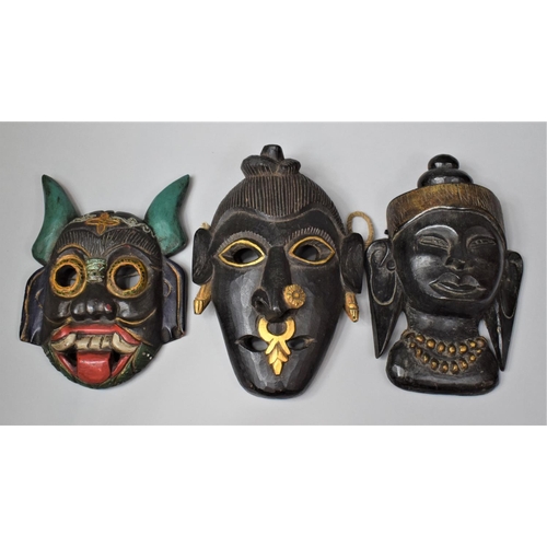 170 - A Collection of Three Eastern Carved Wooden Souvenir Tribal Masks