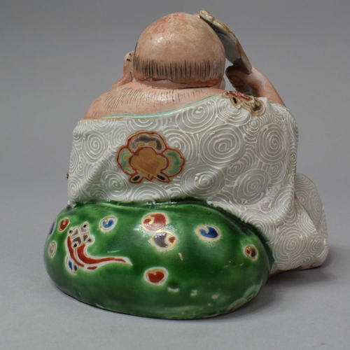 263 - A Japanese Porcelain Figure of Reclining Buddha with Fan, Meiji Period, 13.5cm High