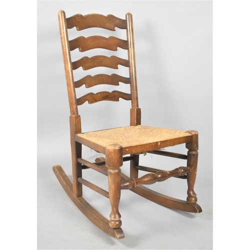 658 - A Rush Seated Ladder Back Rocking Chair