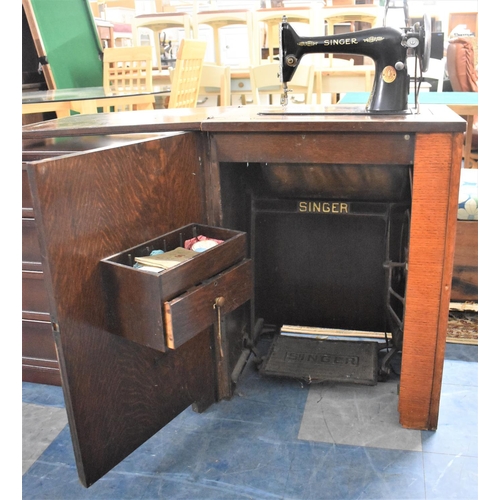 662 - An Oak Cased Singer Treadle Sewing Machine