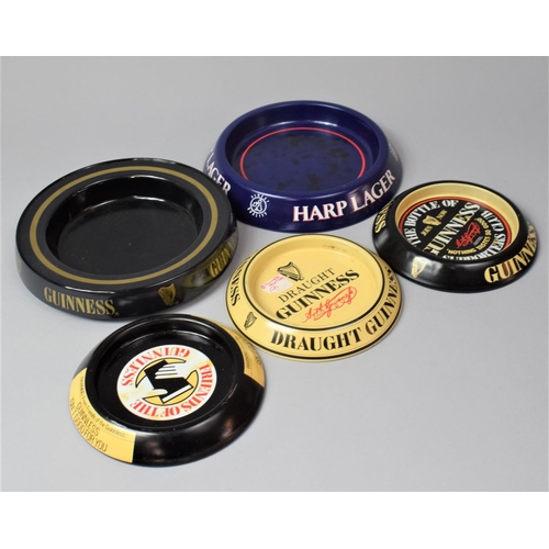 312 - A Collection of Four Guinness and Harp Pressed Metal Advertising Ashtrays