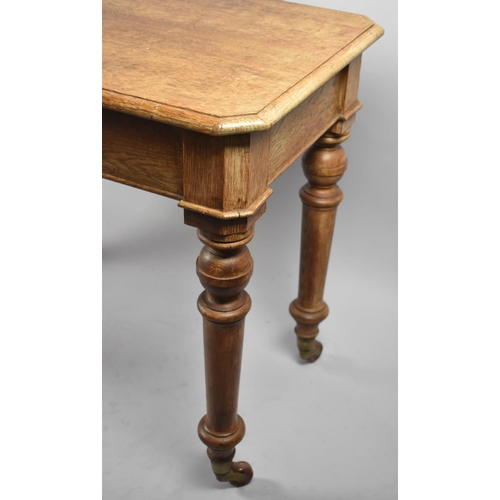 93 - A Late 19th Century Oak Rectangular Side Table with Turned Supports and Casters, 90cm Long