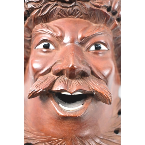 103 - A Far Eastern Carved Wooden Mask Depicting Warrior God with Dragons on Head, 23cm high