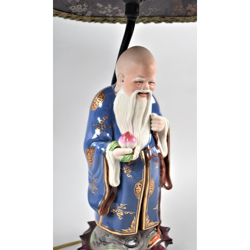 60 - A Chinese Figural Table Lamp in the Form of Shou Lao Holding Peach of Longevity, Complete with Shade