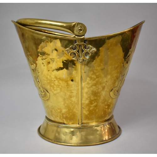 87 - A Brass Helmet Shaped Coal Scuttle with Pressed Art Nouveau Floral Decoration, 33cm High