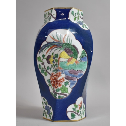 387 - A Chinese Powder Blue Octagonal Vase of Shaped Form with Floral Cartouches. 31cms High