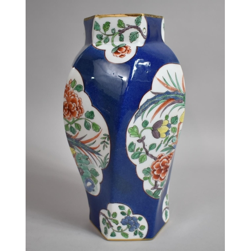 387 - A Chinese Powder Blue Octagonal Vase of Shaped Form with Floral Cartouches. 31cms High