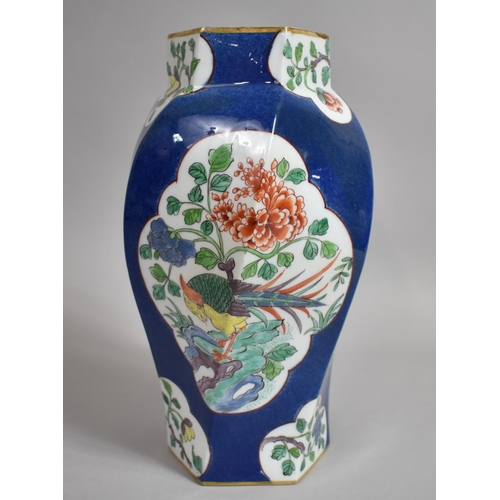 387 - A Chinese Powder Blue Octagonal Vase of Shaped Form with Floral Cartouches. 31cms High