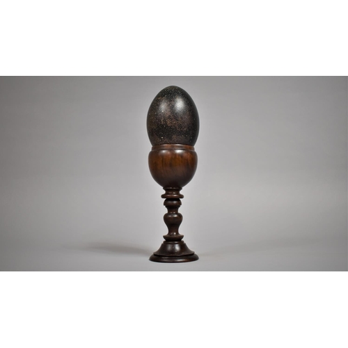 78 - An Emu Egg Mounted on a Turned Wooden Stand. 30cms High