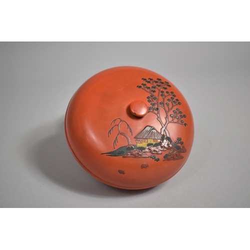 96 - A Japanese Circular Lacquered Box, The Lid Decorated in Relief with House and Trees. 16cms Diameter